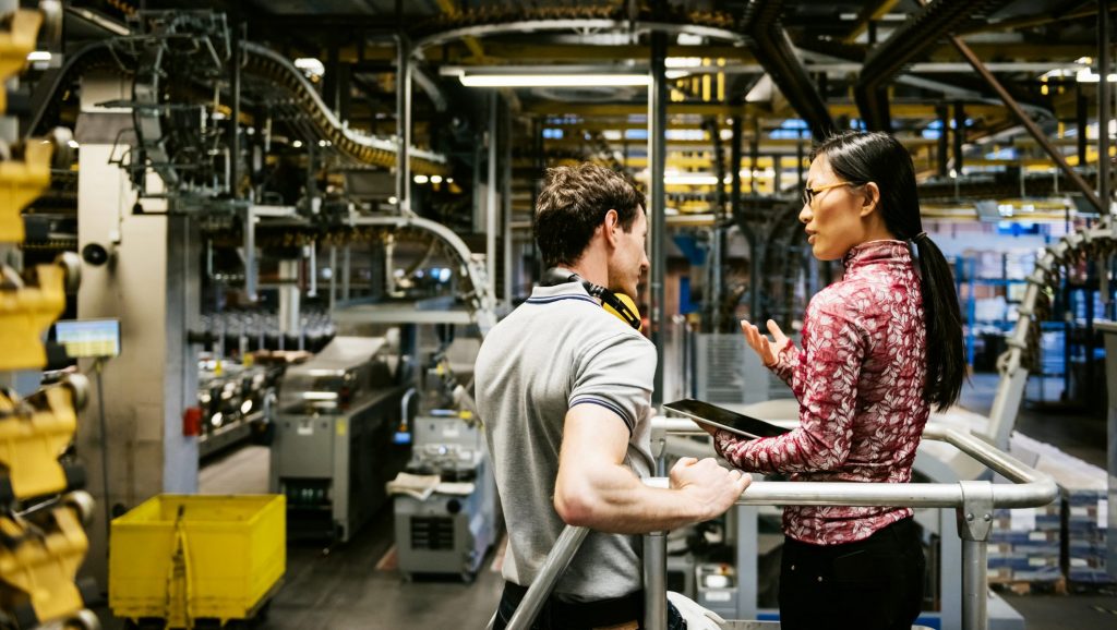 Two people discussing something in a factory